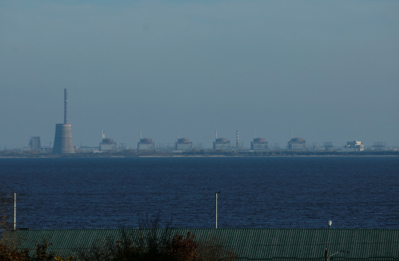 A view shows Zaporizhzhia Nuclear Power Plant from the town of Nikopol, amid Russia's attack on Ukraine, in Dnipropetrovsk region, Ukraine November 7, 2022. Picture taken through glass. (credit: REUTERS/VALENTYN OGIRENKO/FILE PHOTO)