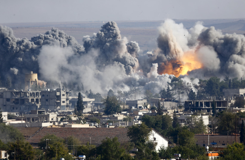 Smoke rises over Syrian town of Kobani after an airstrike, as seen from the Mursitpinar border crossing on the Turkish-Syrian border in the southeastern town of Suruc in Sanliurfa province, October 18, 2014. (photo credit: REUTERS/KAI PFAFFENBACH)