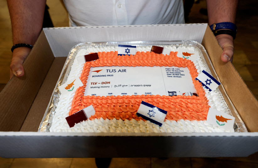 A man holds a cake decorated as a boarding pass, marking the first direct commercial flight between Israel and Qatar for the 2022 FIFA World Cup Qatar, at Ben Gurion International Airport, near Tel Aviv, Israel, November 20, 2022. (credit: REUTERS/AMIR COHEN)