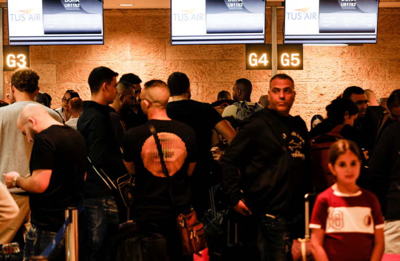 Soccer fans line up before boarding the first direct commercial flight between Israel and Qatar for the upcoming 2022 FIFA World Cup, at Ben Gurion International Airport, near Tel Aviv, Israel, November 20, 2022. (photo credit: REUTERS/AMIR COHEN)