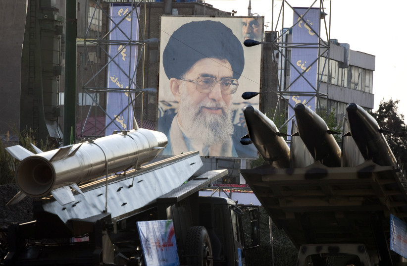 Iranian-made Fateh 110 (Conqueror) (L) and Persian Gulf (R) missiles are seen next to a portrait of Iran's Supreme Leader Ayatollah Ali Khamenei at a war exhibition  (credit: Morteza Nikoubazl/Reuters)