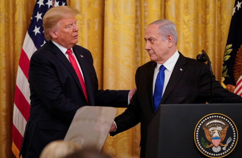  Then-US president Donald Trump and Israeli prime minister Benjamin Netanyahu shake hands announcing Middle East peace proposal at news conference at White House in Washington. January 28, 2020. (credit: REUTERS/JOSHUA ROBERTS)