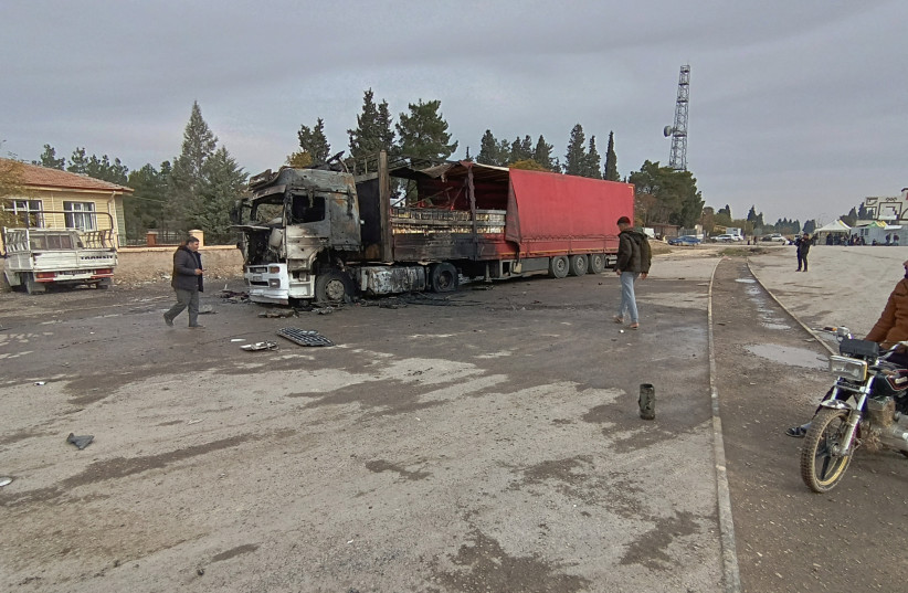  Locals inspect a burned truck hit by one of the rockets fired from northern Syria in the Karkamis district, near a border gate in Gaziantep province, Turkey November 21 2022. (photo credit: IHA via REUTERS)