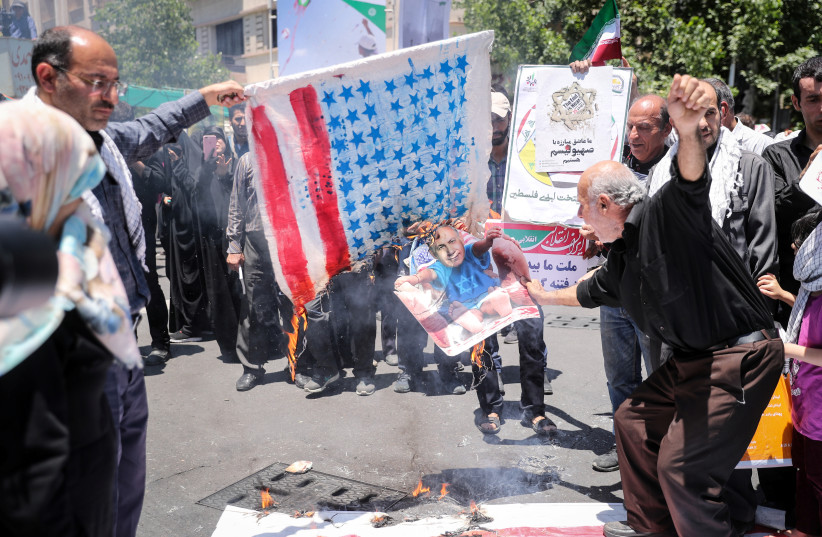 Iraníes queman un paño similar a la bandera de los EE. UU. y una imagen de Benjamín Netanyahu (2018)