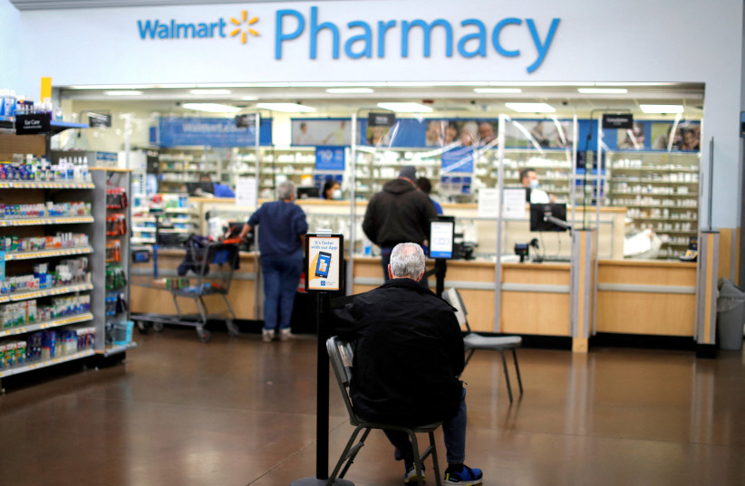  A person waits at a Walmart Pharmacy in West Haven, Connecticut (photo credit: REUTERS)