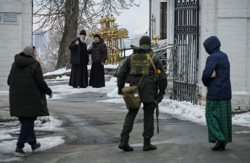  Orthodox priests look at a member of Ukrainian law enforcements at a compound of the Kyiv Pechersk Lavra monastery, amid Russia's attack on Ukraine, in Kyiv, Ukraine (credit: REUTERS)