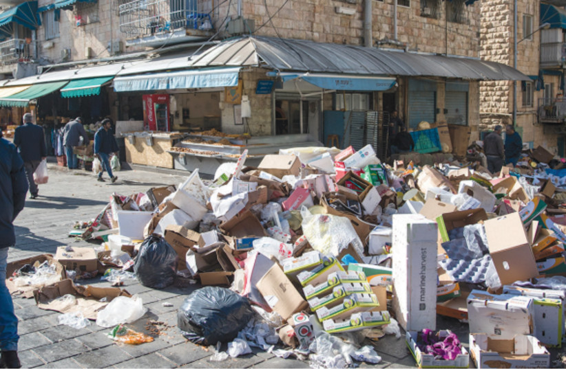  A SCENE FROM the 2018 strike by city workers that left garbage piles at the Mahaneh Yehuda market. (photo credit: YONATAN SINDEL/FLASH90)