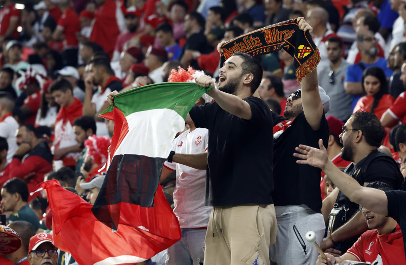   A fan displays a Palestine flag in the stands during the FIFA World Cup in Qatar, November 23, 2022 (photo credit: REUTERS/SUHAIB SALEM)