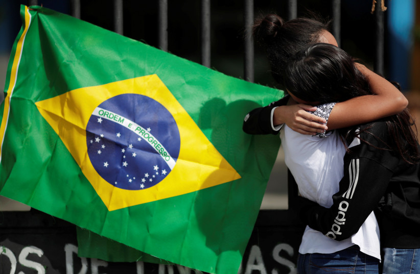  Students cry during a tribute to victims of the shooting at the Raul Brasil school in Suzano, Brazil March 19, 2019. (credit: REUTERS/UESLEI MARCELINO)