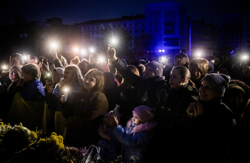  Ukrainian musician Kolya Serga (nor pictured) plays to a crowd holding up the lights on their cell phones in Kherson's central Freedom Square, in Kherson, Ukraine, November 18, 2022. (credit: Ed Ram/Pool via REUTERS)