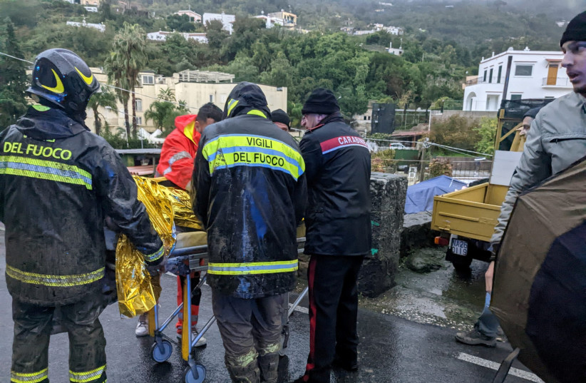  Rescuers help an injured person following a landslide on the Italian holiday island of Ischia, Italy, in this handout photo obtained by Reuters on November 26, 2022. (credit: Carabinieri/Handout via REUTERS)