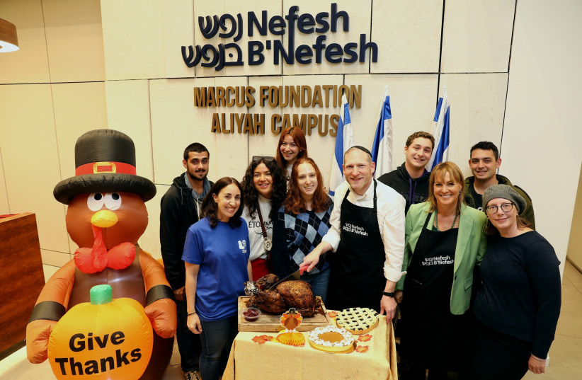  Rabbi Yehoshua Fass, Co-Founder of Nefesh B’Nefesh, Bonnie Rosenbaum, Co-Director of The Michael Levin Base, Noya Govrin, Director of the FIDF, surrounded by lone soldier Olim attending the Thanksgiving dinner at the Nefesh B’Nefesh Aliyah campus. (photo credit: YONIT SCHILLER)