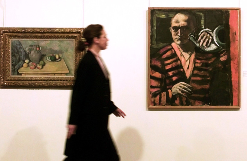  A visitor looks at paintings of French impressionist Paul Cezanne entitled ''Pichet et fruits sur une table'' (L) and at Max Beckmann ''Selbstbildnis mit Horn'' (R) at Sotheby's in Zurich April 9, 2001. The Cezanne will be auctioned at an estimated price of $14-20 million and the Beckmann at $7-10 mill (credit: REUTERS)