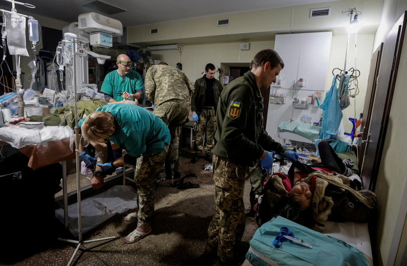 Healthcare workers treat a wounded Ukrainian serviceman and a local resident in a pre-hospital medical aid centre, as Russia's attack on Ukraine continues, in Donetsk region, Ukraine, November 22, 2022. (credit: RADIO FREE EUROPE/RADIO LIBERTY/SERHII NUZHNENKO VIA REUTERS)