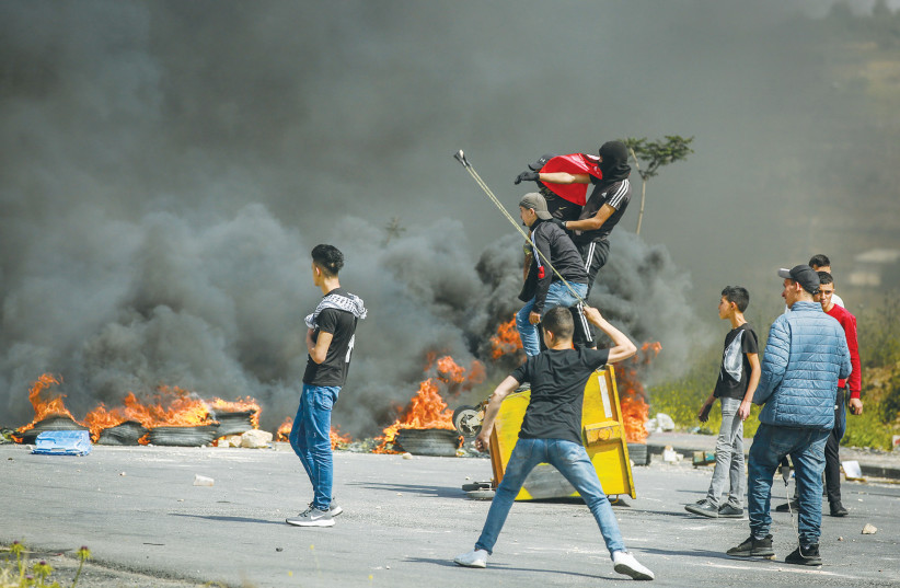  MAY 2018: Palestinians clash with Israeli soldiers near Ramallah during a protest to mark the anniversary of the Nakba. This upcoming May, Palestinians will not be joining Israelis in celebrating the 75-year existence of the Jewish state. Instead, they will mourn their Nakba, says the writer. (photo credit: FLASH90)