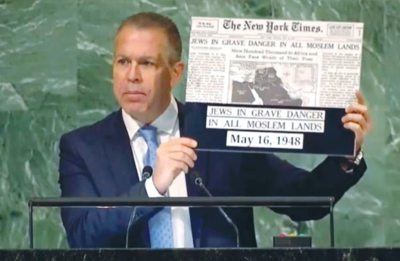  SPEAKING FROM the General Assembly podium on Wednesday, UN Ambassador Gilad Erdan holds up a headline story from the ‘New York Times,’ in the aftermath of the establishment of the State of Israel, which warns of the ‘grave danger’ facing Jews in Muslim lands.  (photo credit: PERMANENT MISSION OF ISRAEL TO THE UN)