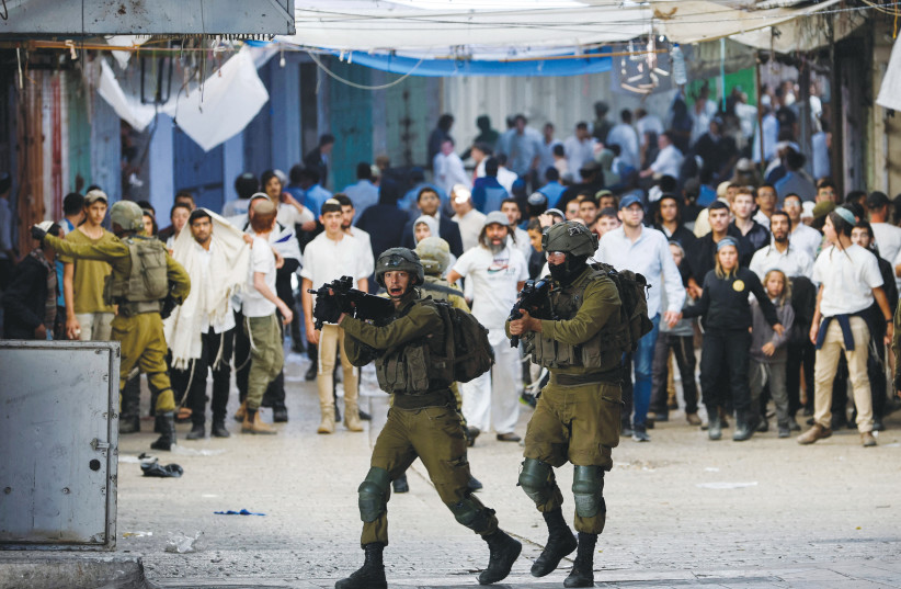  IDF SOLDIERS intervene amid tension between Israelis and Palestinians in Hebron last month (credit: MUSSA QAWASMA/REUTERS)
