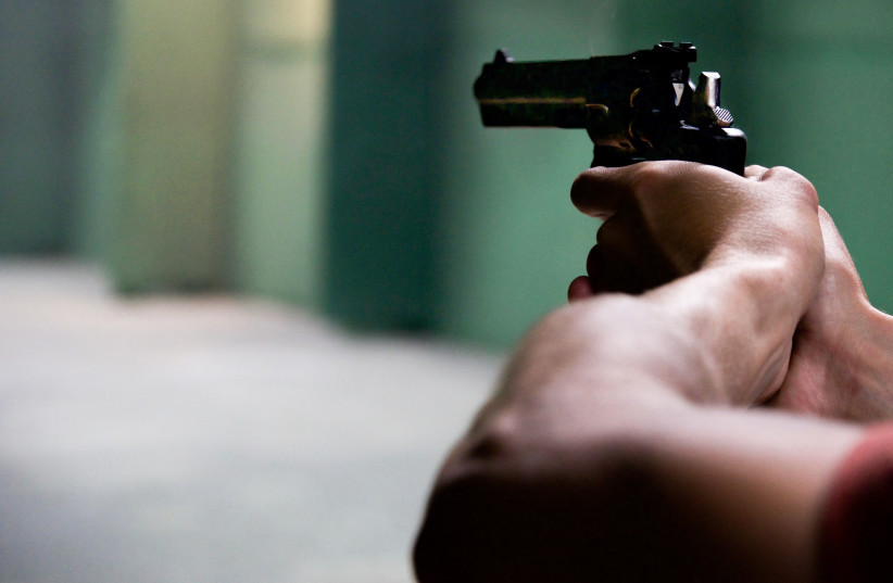  Person pointing a gun at unseen target (illustrative) (photo credit: PEXELS)