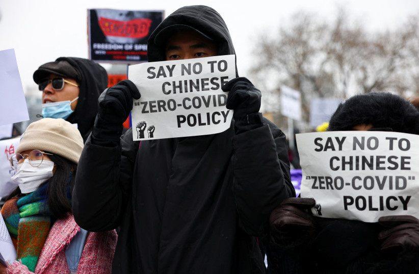  Demonstrators hold placards during a protest against China's coronavirus disease (COVID-19) restrictions, in Berlin, Germany (photo credit: Christian Mang/Reuters)
