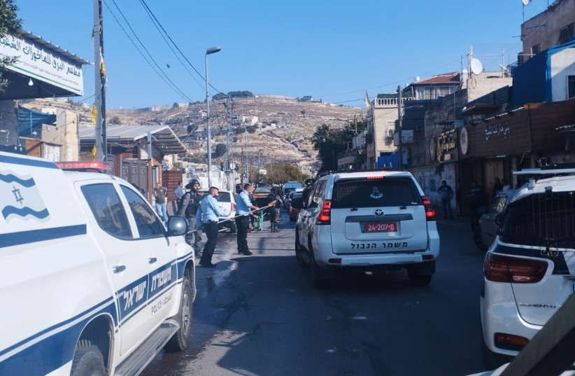  Israel Police officers are seen taking down a Hamas flag in the Palestinian neighborhood of Silwan, Jerusalem on December 4, 2022 (credit: ISRAEL POLICE)