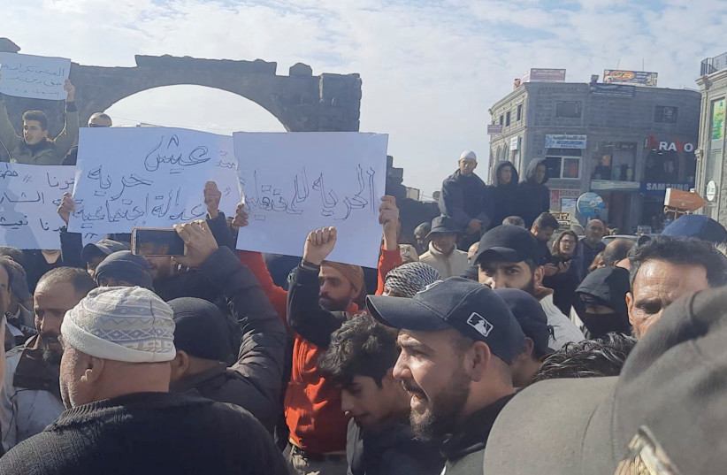  People hold placards as they gather during a protest in Sweida, Syria, December 4, 2022, in this screen grab obtained from a social media video. (credit: Suwayda 24/via REUTERS)