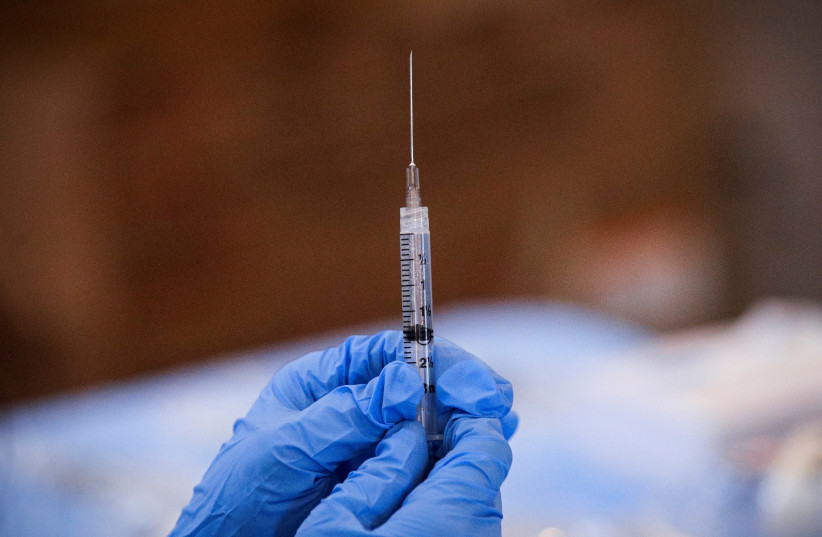  A syringe is filled with a dose of Pfizer's coronavirus disease (COVID-19) vaccine at a pop-up community vaccination center in Valley Stream, New York (photo credit: REUTERS)