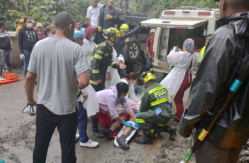  Police help the rescue operations of a bus that was buried after a landslide due to heavy rains in Pueblo Rico, Colombia  (credit: Colombia National Police/Handout via REUTERS)