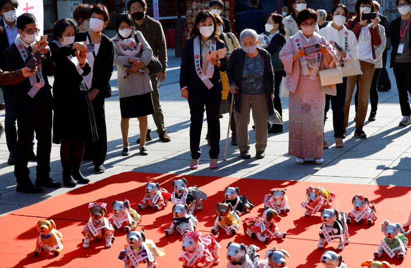   People watch Sony's robotic dogs 'Aibo' during a ritual ceremony Sichi-Go-San, which is usually held for praying for children's health and wellbeing, at the Kanda Myojin shrine in Tokyo, Japan, November 11, 2022. (credit: REUTERS/KIM KYUNG-HOON/FILE PHOTO)