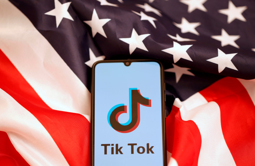 TikTok logo is displayed on the smartphone while standing on the US flag in this illustration picture taken, November 8, 2019. (photo credit: REUTERS/DADO RUVIC/FILE PHOTO)