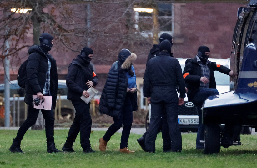  Police escorts a person after 25 suspected members and supporters of a far-right group were detained during raids across Germany, in Karlsruhe, Germany December 7, 2022. (credit: REUTERS/HEIKO BECKER)