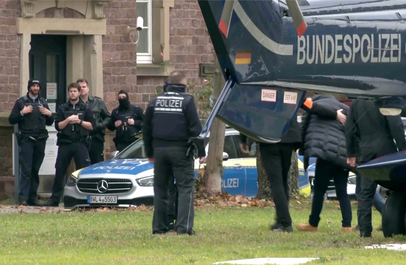  Police escorts a person in this screen grab from Reuters TV, after 25 suspected members and supporters of a far-right group were detained during raids across Germany, in Karlsruhe, Germany December 7, 2022. (photo credit: REUTERS/REUTERS TV/FILES)