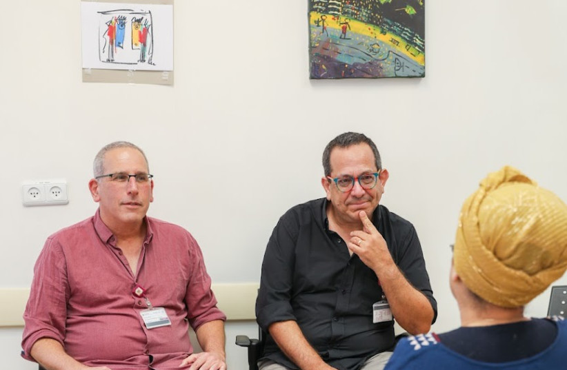  Photo of conversation between a female patient and Dr. Eyal Fruchter, director of the mental health division at Rambam on the right; next to him is Avi Levy, director of the social work department in the psychiatry division at Rambam. (credit: RAMBAM HEALTHCARE CAMPUS)