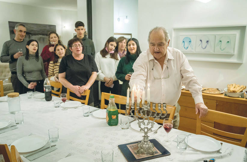  A FAMILY comes together for Hanukkah candle lighting and a meal. (photo credit: NATI SHOHAT/FLASH90)
