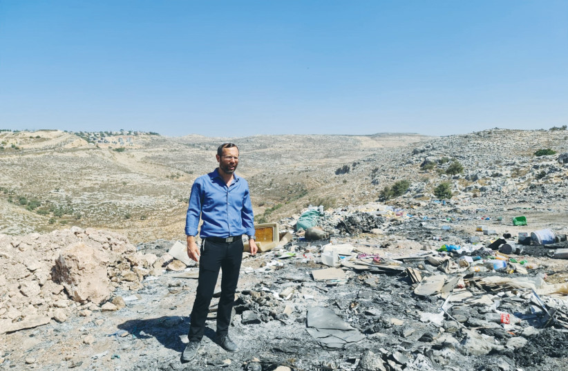  THE WRITER stands on an illegal garbage dump near Dir Kadis. (photo credit: International Desk, Binyamin Regional Council)