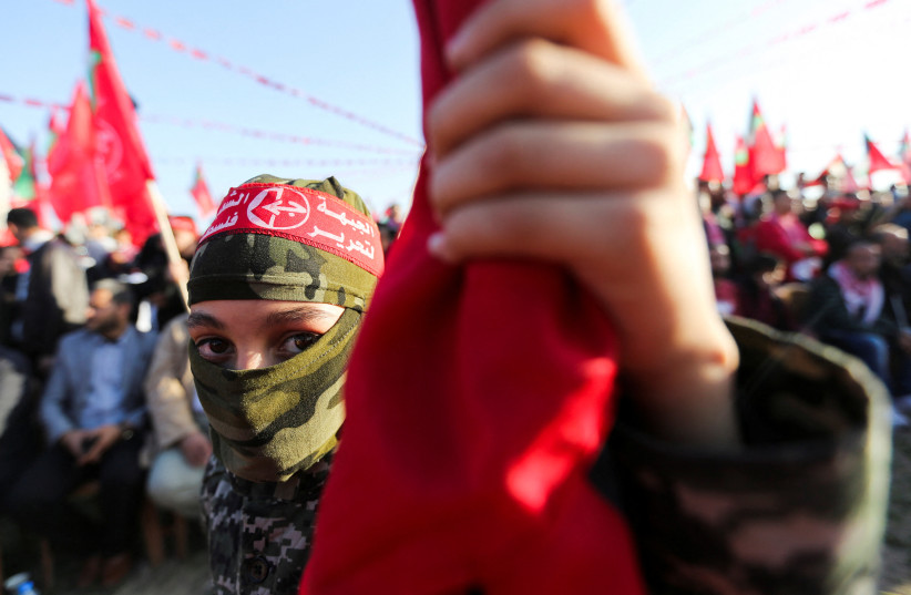A Palestinian boy wearing a headband of the Popular Front for the Liberation of Palestine (PFLP) takes part during a rally on the 55th anniversary of the founding of (PFLP), in Gaza City, December 8, 2022. (credit: REUTERS/IBRAHEEM ABU MUSTAFA)