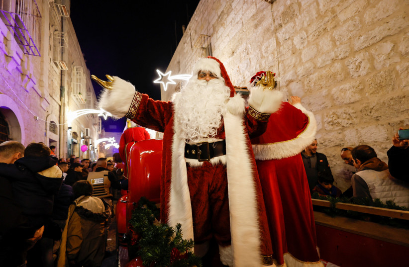  A Palestinian dressed as Santa Claus gestures during a celebration in Bethlehem, in the West Bank, December 4, 2022.  (photo credit: REUTERS/MUSSA QAWASMA)