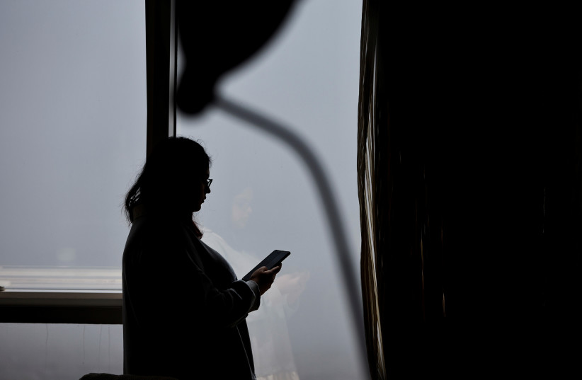  A blogger and social media specialist, Hera Shabbir checks her social media accounts on her smart phone in Manama, Bahrain (photo credit: REUTERS)