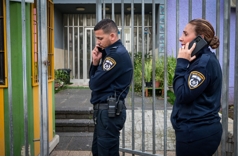  Police officers guard the entrance to a school in Rehovot, where a boy studying at the school was stabbed by 4 masked men, December 13, 2022. (credit: AVSHALOM SASSONI/FLASH90)