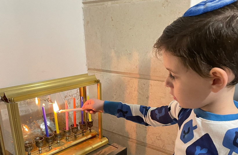  THE WRITER’S grandson Lavi lights the ‘hanukkiah.’ (photo credit: AYELET COHEN)