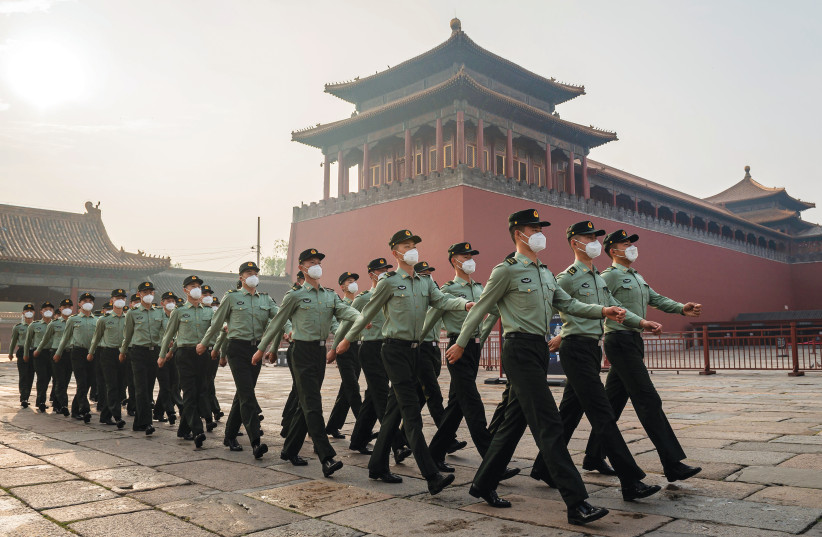  PEOPLE’S LIBERATION Army soldiers march next to the entrance to the Forbidden City, in Beijing.  (photo credit: Nicolas Asfouri/AFP via Getty Images)
