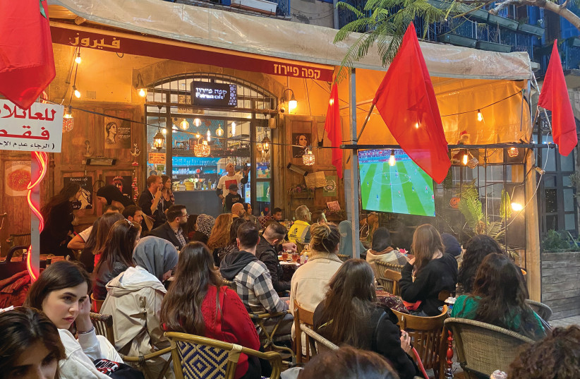  FANS IN Jaffa watch Wednesday night’s World Cup semifinal match between France and Morocco. (photo credit: Owen Alterman, i24NEWS)