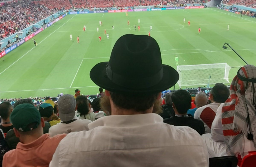  ABBI ELI CHITRIK watches a World Cup match, wearing a traditional Orthodox Jewish hat, even as a Muslim wearing a keffiyeh is among the other fans sitting nearby. (photo credit: Rabbi Mendy Chitrik)