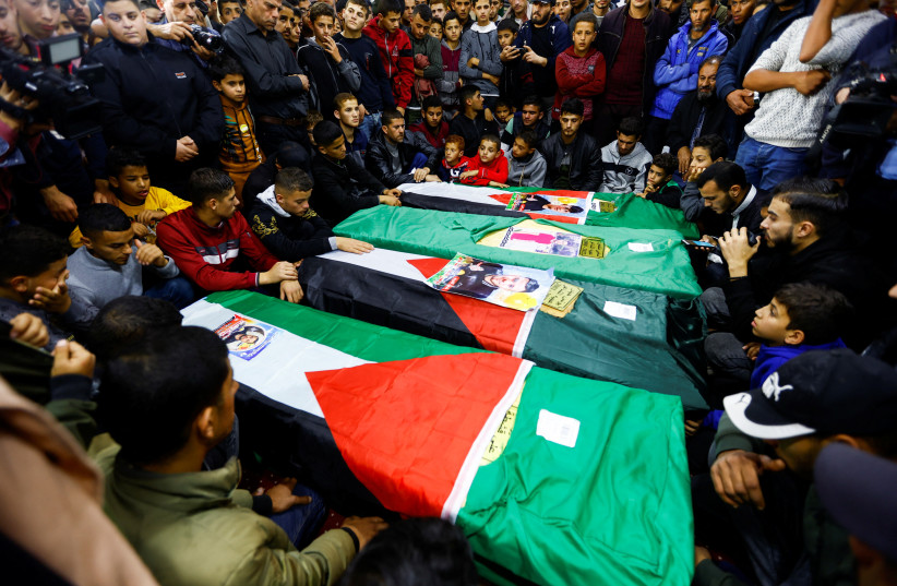 Palestinians attend the funeral of 8 people, who died when a ship carrying migrants drowned offshore Tunisia in October, in Rafah, in the southern Gaza Strip, December 18, 2022. (photo credit: REUTERS/IBRAHEEM ABU MUSTAFA)