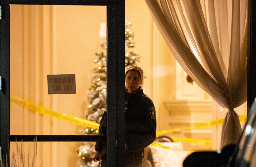  A police officer looks out from the lobby after a fatal mass shooting at a condominium building in the Toronto suburb of Vaughan, Ontario, Canada December 19, 2022 (credit: REUTERS/CARLOS OSORIO)