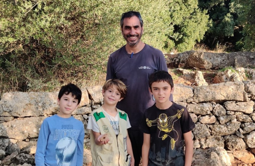   Dr. Haim Mamalia of Israel's Antiquities Authority with the children who found the candle. (photo credit: SHAKED COHEN)