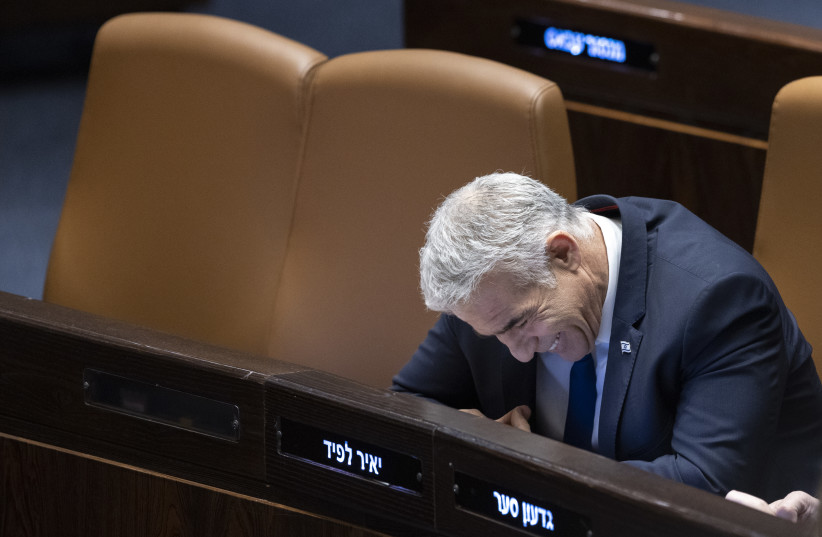  Israeli Prime Minister Yair Lapid seen laughing during a plenum session at the assembly hall of the Knesset, the Israeli parliament in Jerusalem, on December 19, 2022. (credit: OLIVIER FITOUSSI/FLASH90)