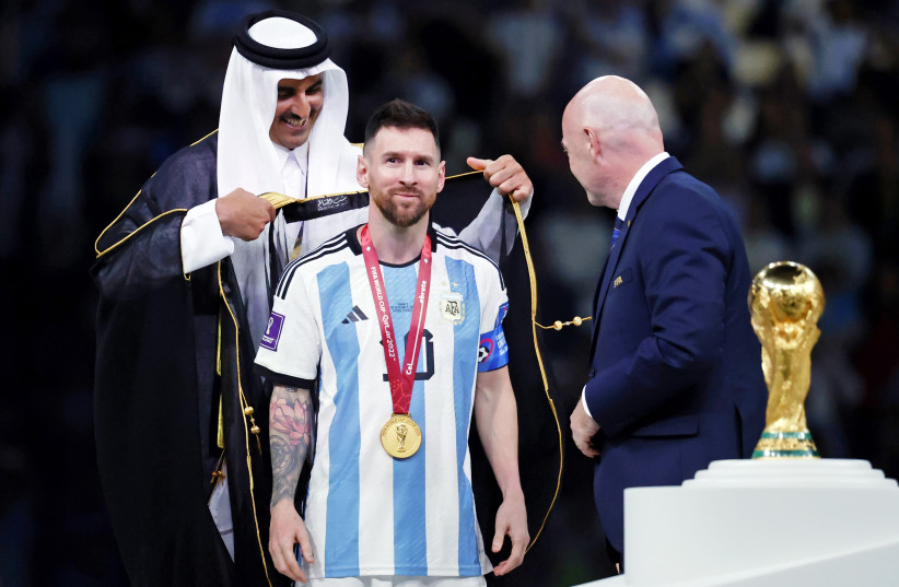 Qatar Emir Sheikh Tamim bin Hamad al Thani presents Argentina forward Lionel Messi (10) with a traditional robe after he won the 2022 World Cup final against France at Lusail Stadium. (photo credit: YUKIHITO TAGUCHI-USA TODAY NETWORK/REUTERS)