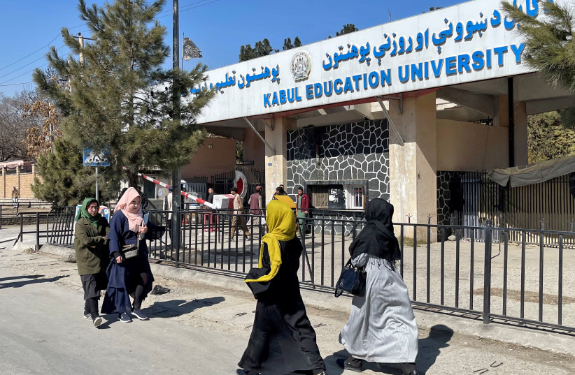 Female students walk in front of the Kabul Education University in Kabul, Afghanistan, February 26, 2022.  (photo credit: REUTERS/STRINGER/FILE PHOTO)