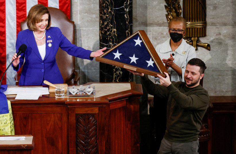  Ukraine's President Volodymyr Zelenskiy receives a U.S. flag from U.S. House Speaker Nancy Pelosi (D-CA) during a joint meeting of the U.S. Congress in the House Chamber of the U.S. Capitol in Washington, U.S., December 21, 2022. (credit: REUTERS/EVELYN HOCKSTEIN)