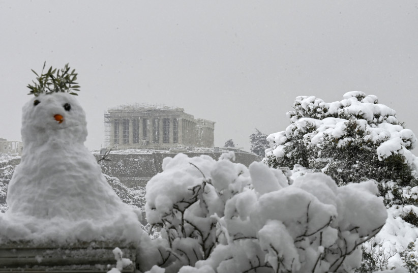  CULTURAL ENCOUNTER: A snowman greets visitors to the Parthenon temple, atop the Acropolis hill, in Athens last year. (photo credit: ARIS MESSINIS/AFP via Getty Images)